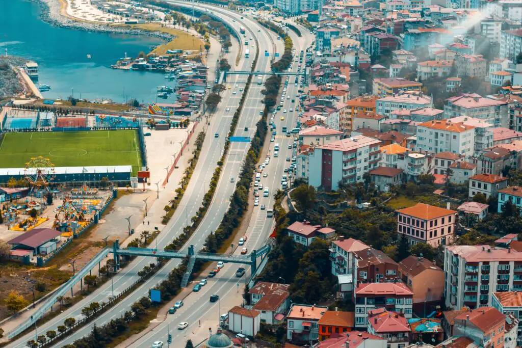 Infrastructure and Property Value: Why Location Matters More Than Ever A vibrant aerial view of a cityscape featuring a highway, buildings, and a river.